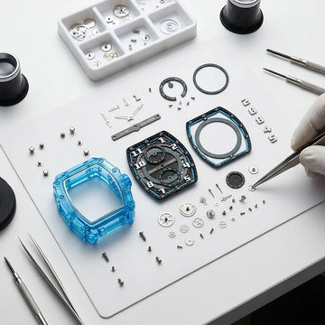 Hudson Mercury Noverque 2B45 tonneau quartz watch components with transparent blue case, detailed dial and watchmaking tools